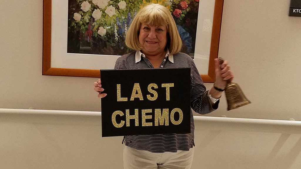 Multiple myeloma survivor Marie Chaplinksy holds up "last chemo" sign