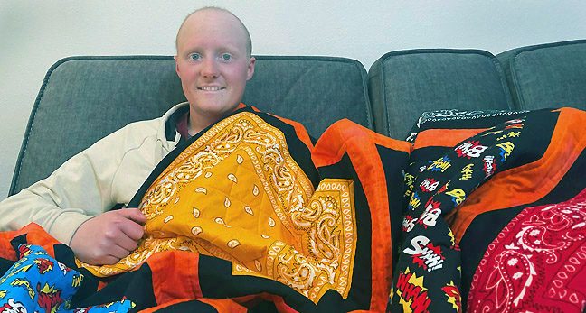 Connor Johnson with the quilt his grandmother made from bandanas he collected.