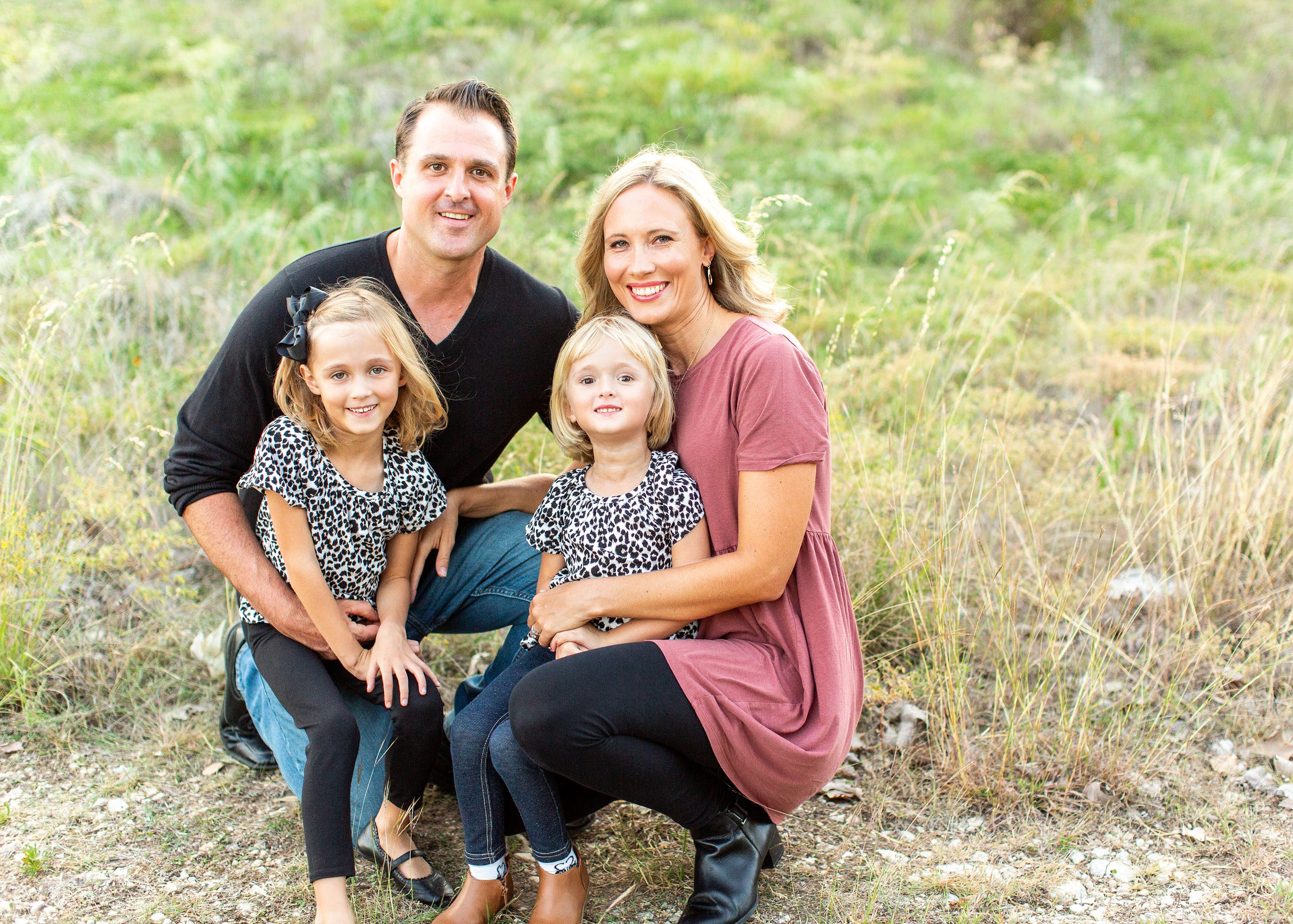 Cassie McKee and her family sitting outside in the grass.