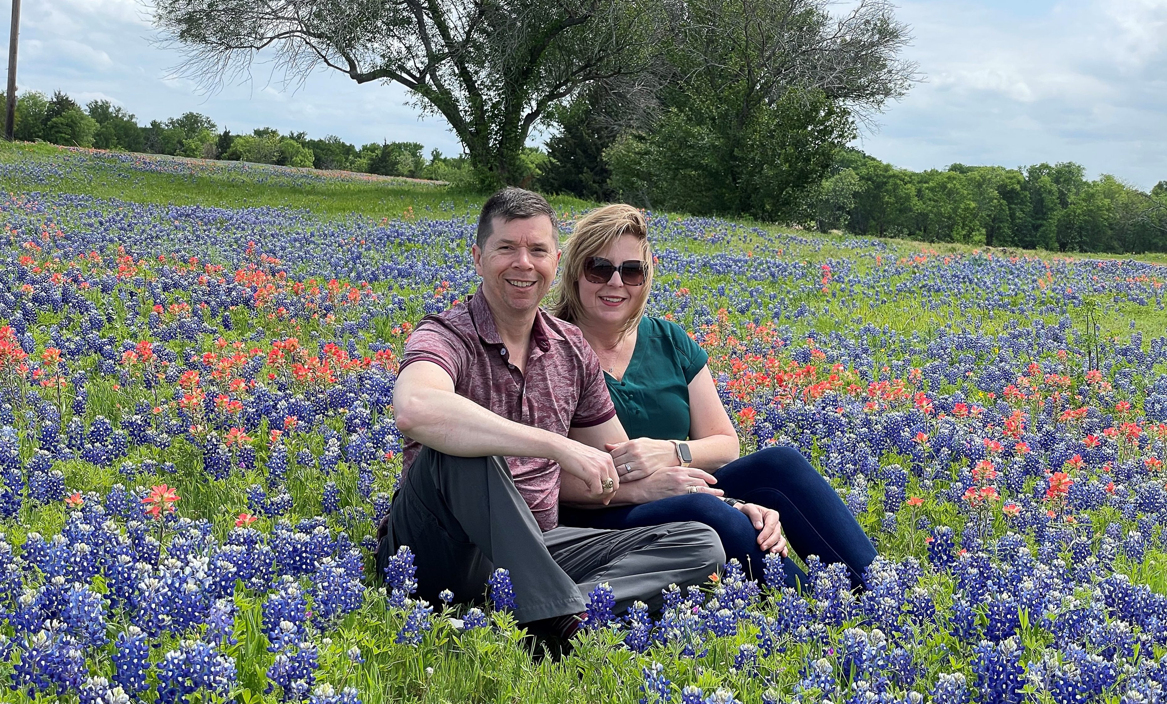 Dana Reeves and her husband, Brad, sit in a field of bluebonnets