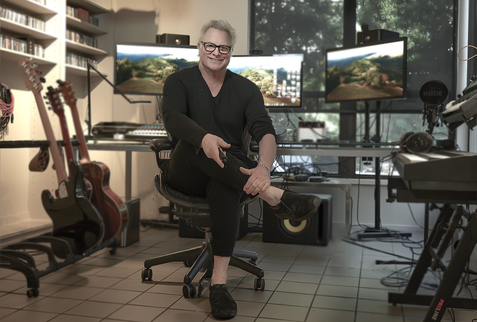 Jay Rusovich sits in a chair in his home studio