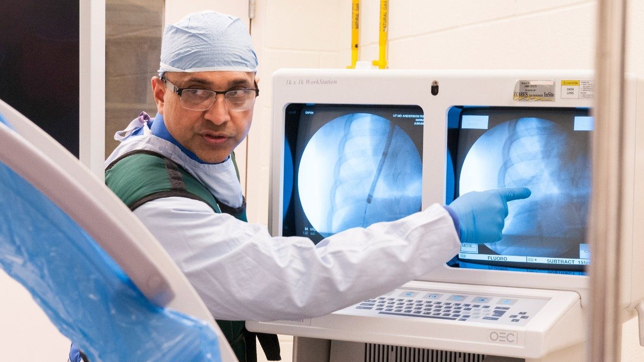 Pulmonologist George Eapen, M.D., examines lungs of patient undergoing cancer treatment