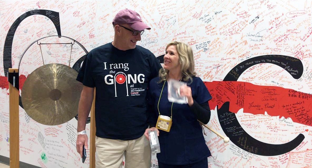 Rob Gales and radiation therapist Denice Jones stand together by the gong at the Proton Therapy Center to mark the end of his treatment on Nov. 3, 2017