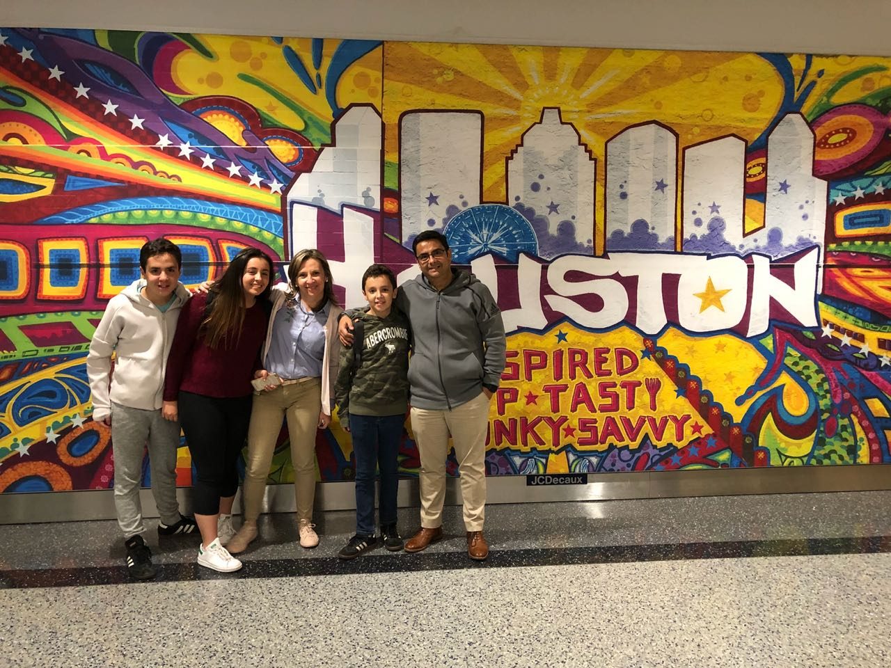 Lorena Bueno (center) with her husband, Guillermo (far right), and their kids stand in front of Houston mural