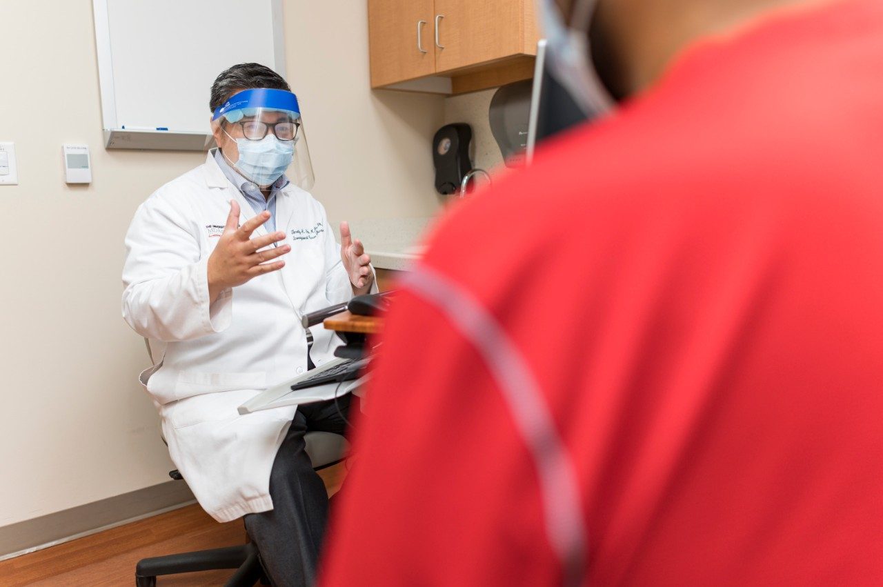 Timothy Yap, M.B.B.S., Ph.D., speaks with a patient