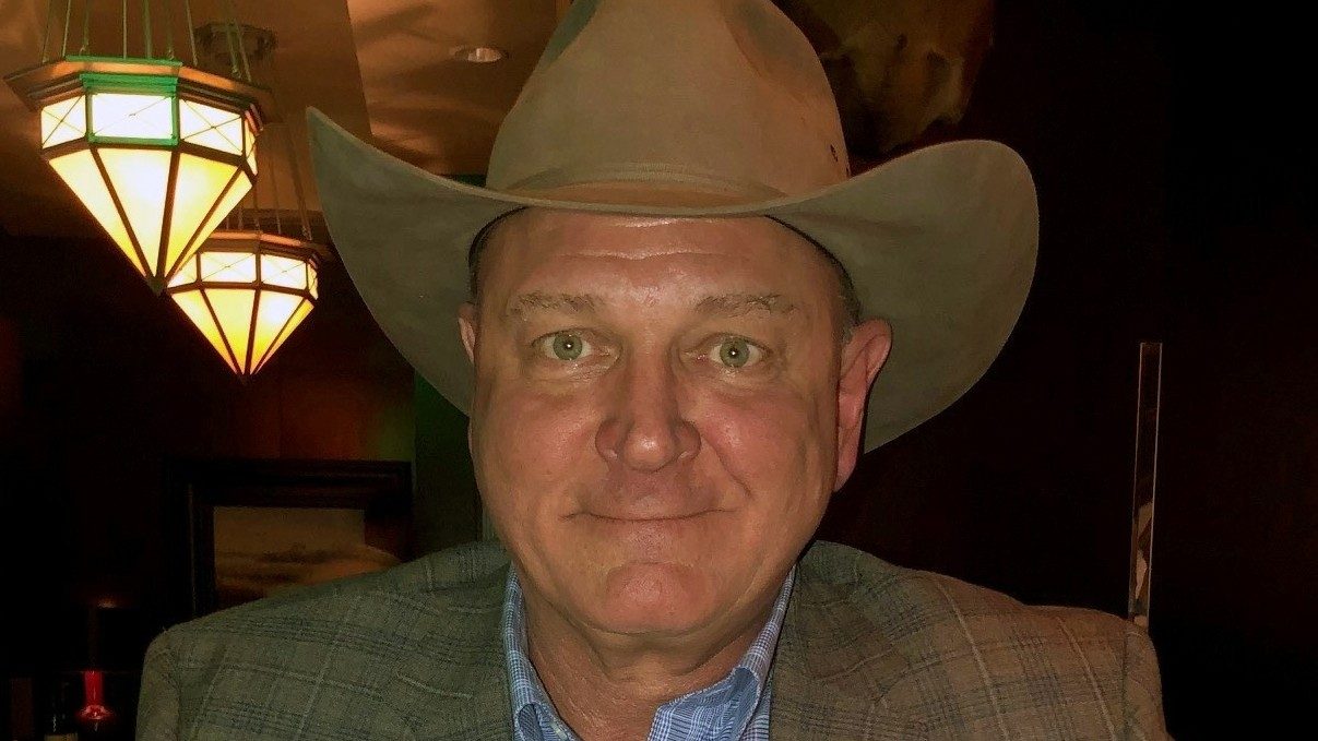 Tonsil cancer survivor Tony Loth poses in a cowboy hat