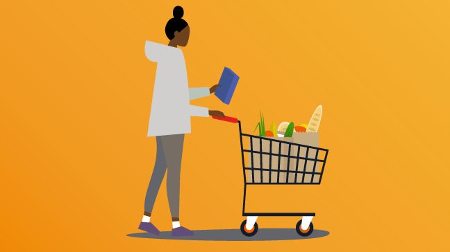 Woman is grocery shopping looking at packet label while she pushes a grocery cart.