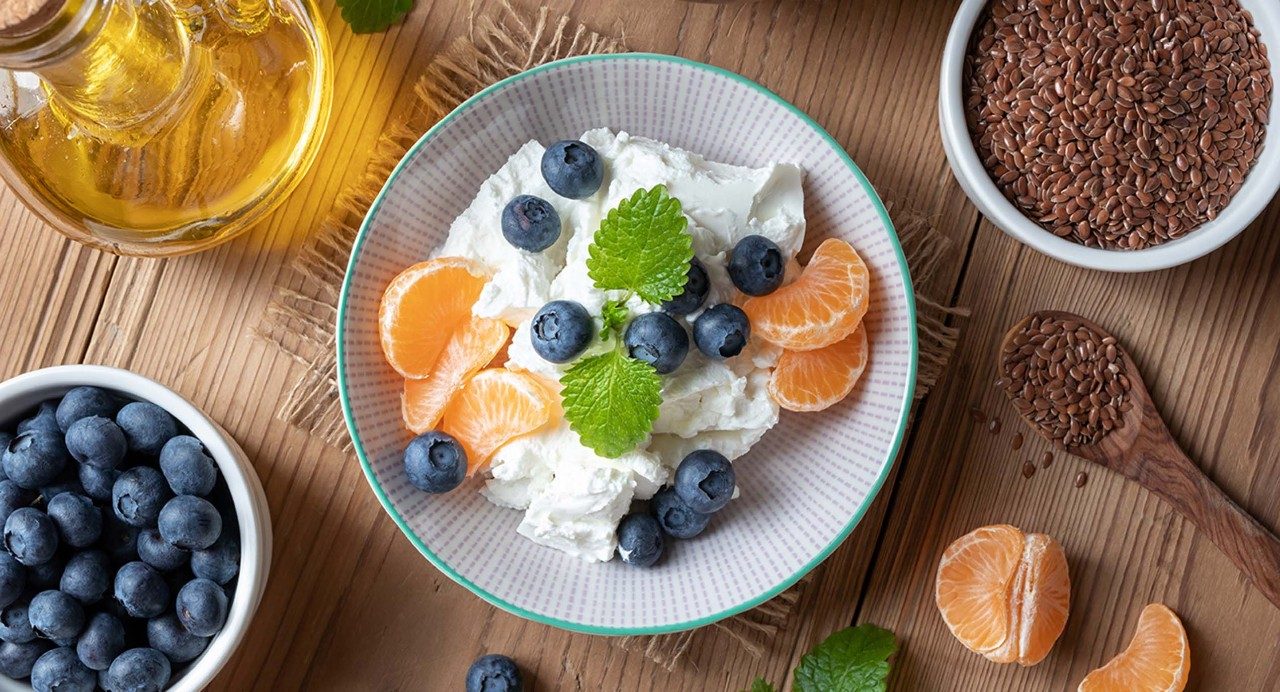 Picture of a Budwig diet-compliant meal, featuring cottage cheese, blueberries, oranges, flaxseed and flaxseed oil