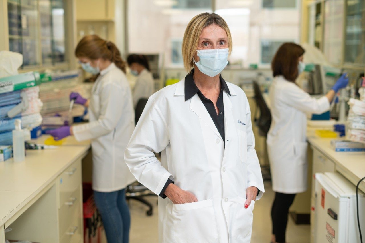 Myelodysplastic syndrome researcher Simona Colla, Ph.D., stands in the lab as other researchers work.