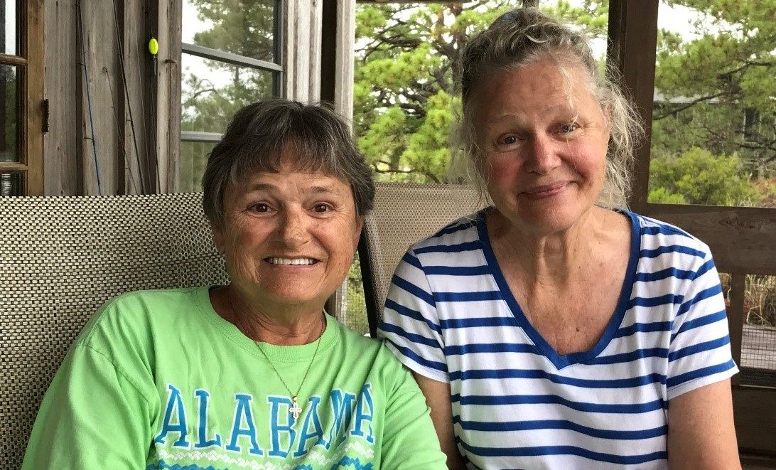 Suzanne Singletary (left) and her sister, Nancy Rathbun, sitting side by side on a couch.