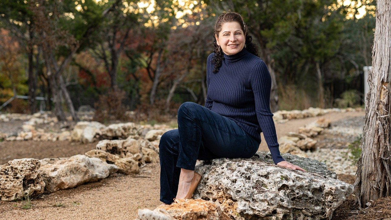 Jacqueline Mason sits on a rock