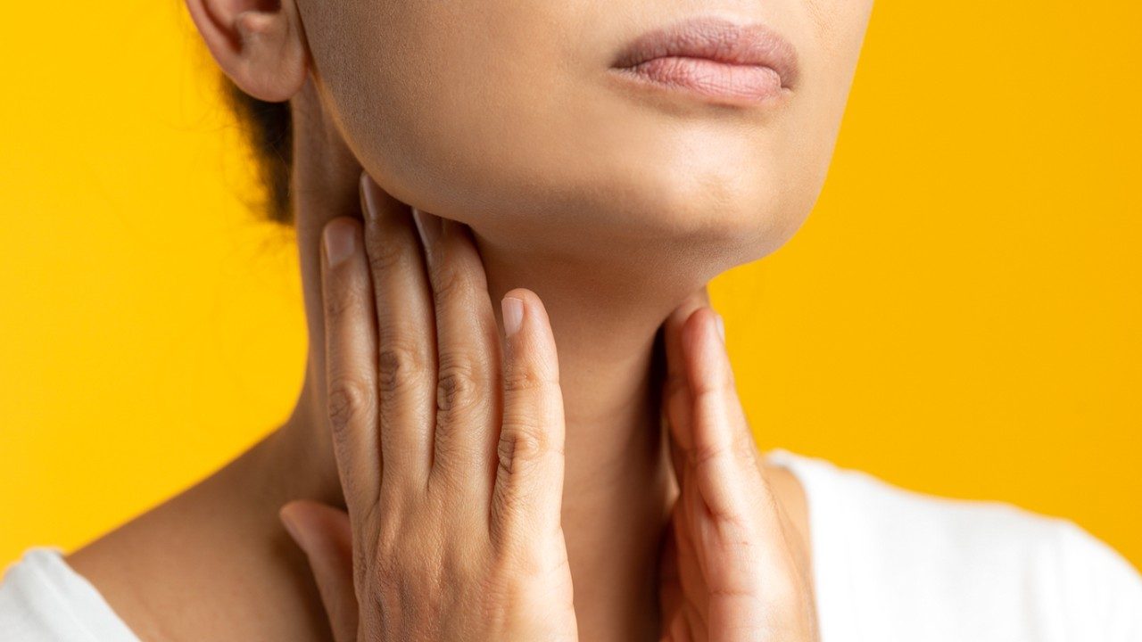 Close-up view of young person touching neck 