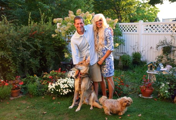 Chris Cook hugs his wife, Essie, and stands next to their two dogs