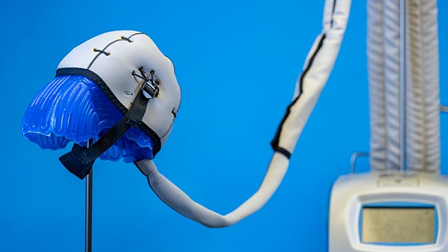 Blue silicone scalp cooling cap connected to the scalp cooling system