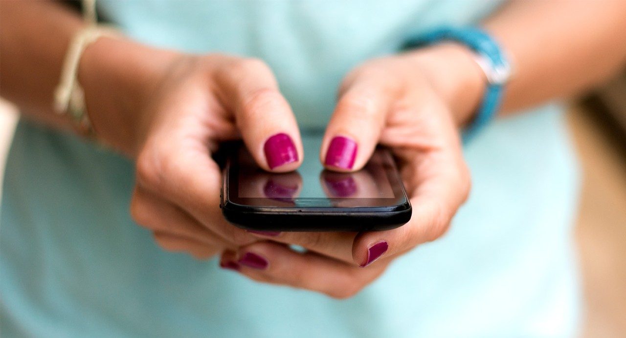 Close-up of woman holding cell phone in hands