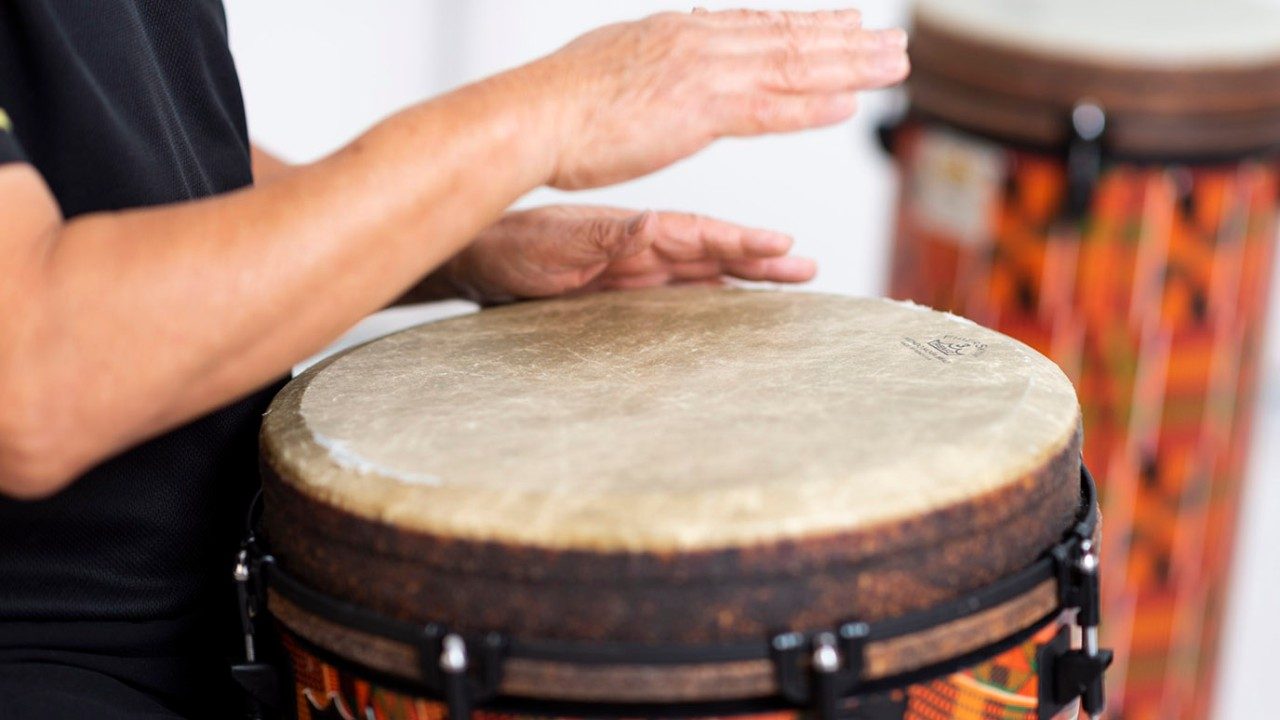 Close-up of two hands and a drum