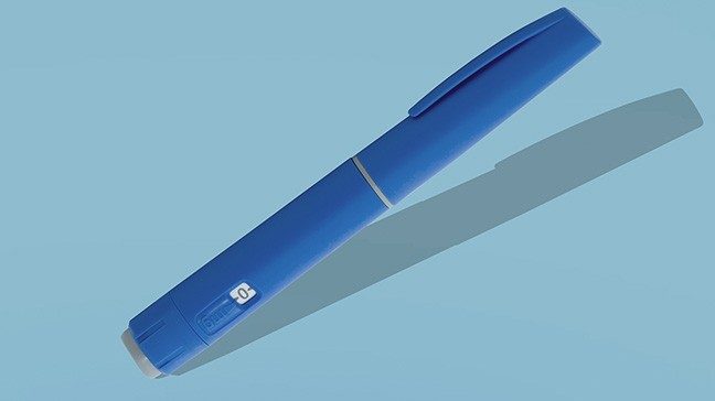 Royal blue weight loss injection "pen" against a light blue background