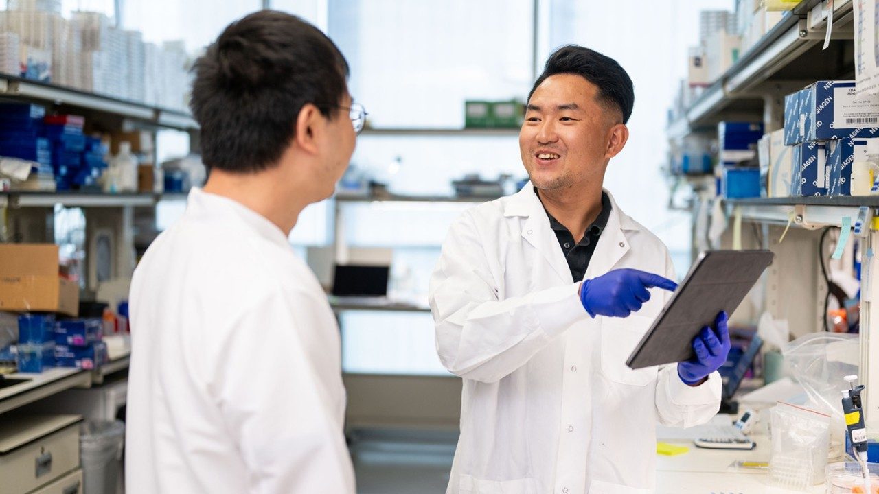 Guang Lei, M.D., Ph.D., with a colleague in the lab