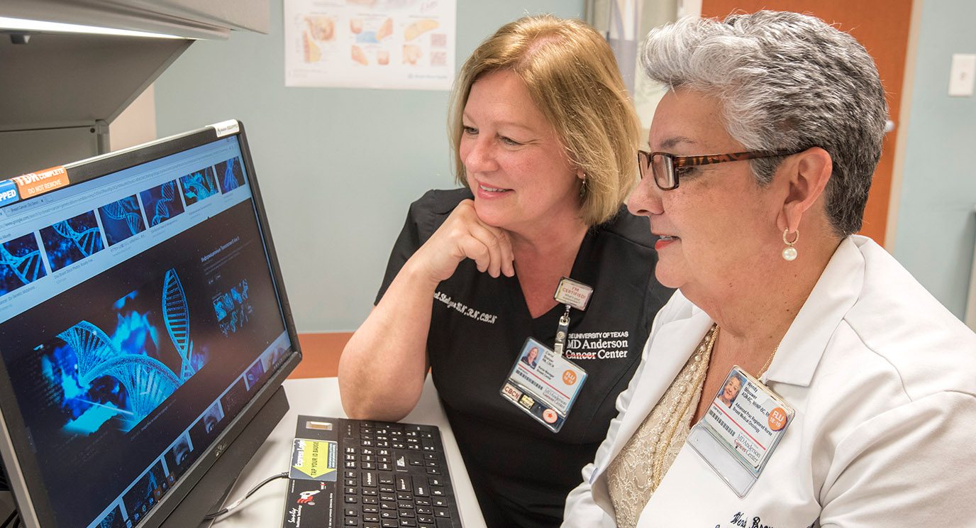 Wendy Brouwer, a women’s health nurse practitioner in Clinical Cancer Prevention, reviews genetic information with nurse manager Carol Stalzer.