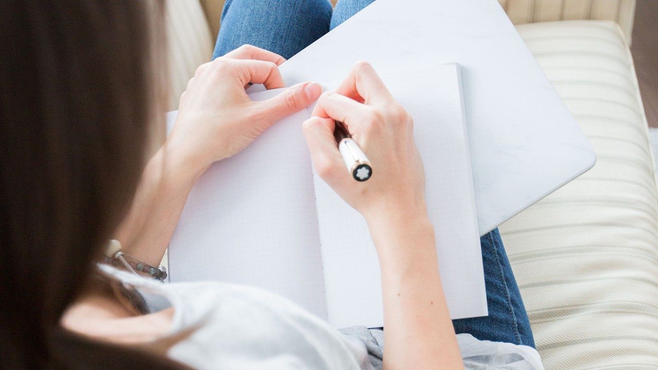 generic photo of woman writing in journal