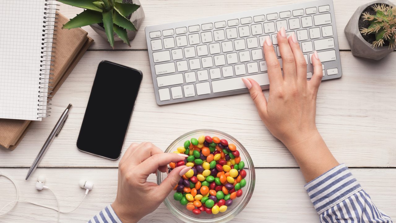 Someone working at a desk eating sweets