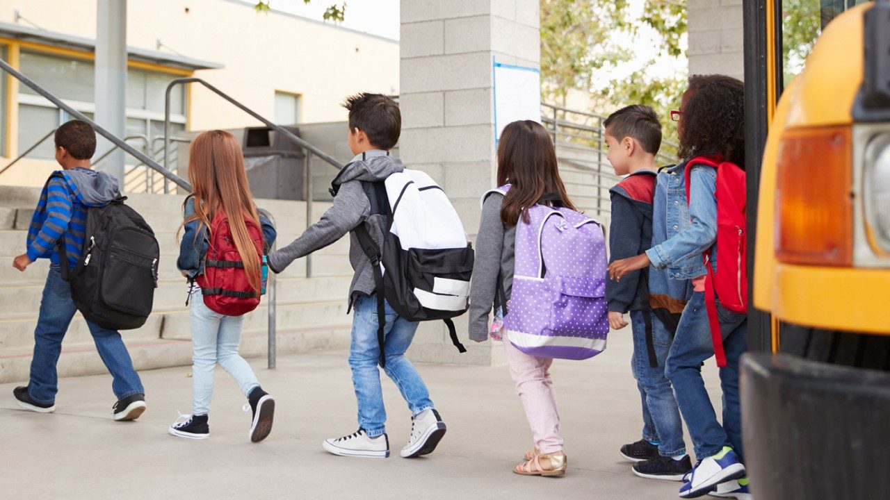 Children get off school bus and file into class