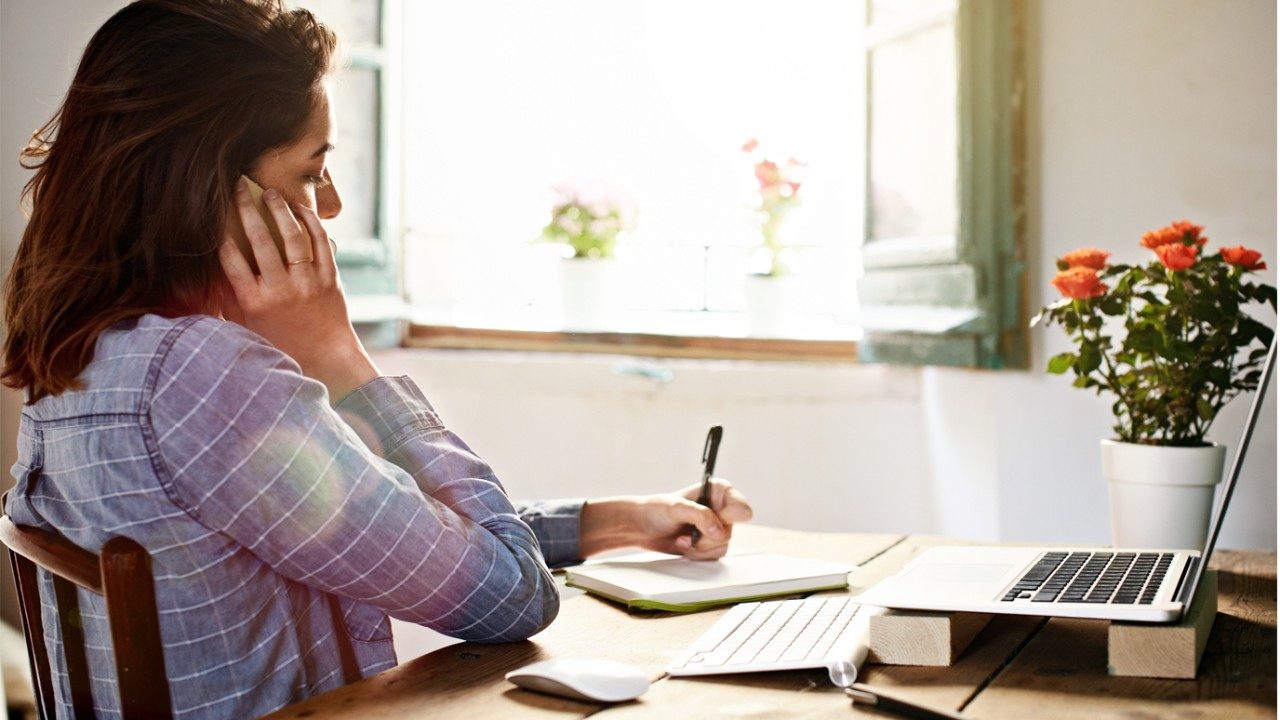 woman on the phone taking notes