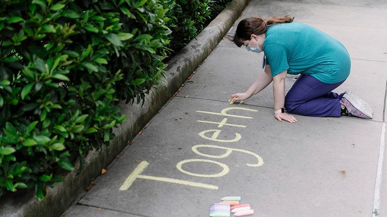 Woman writing on sidewalk with chalk